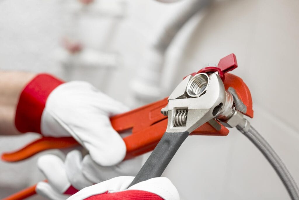 Plumber holding pipe wrenches for an emergency repair in Spring Hill