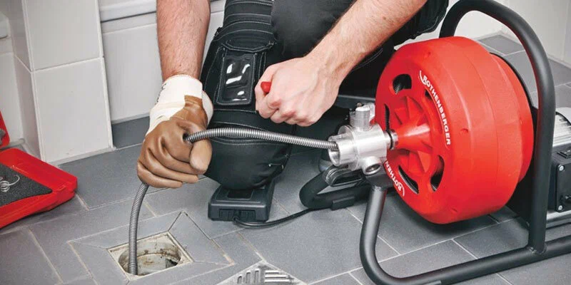 Plumber using a drain-cleaning machine in Spring Hill