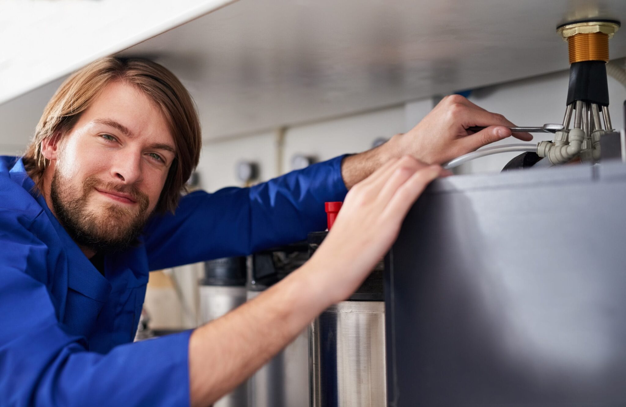 Technician servicing a residential water heater tank in Spring Hill
