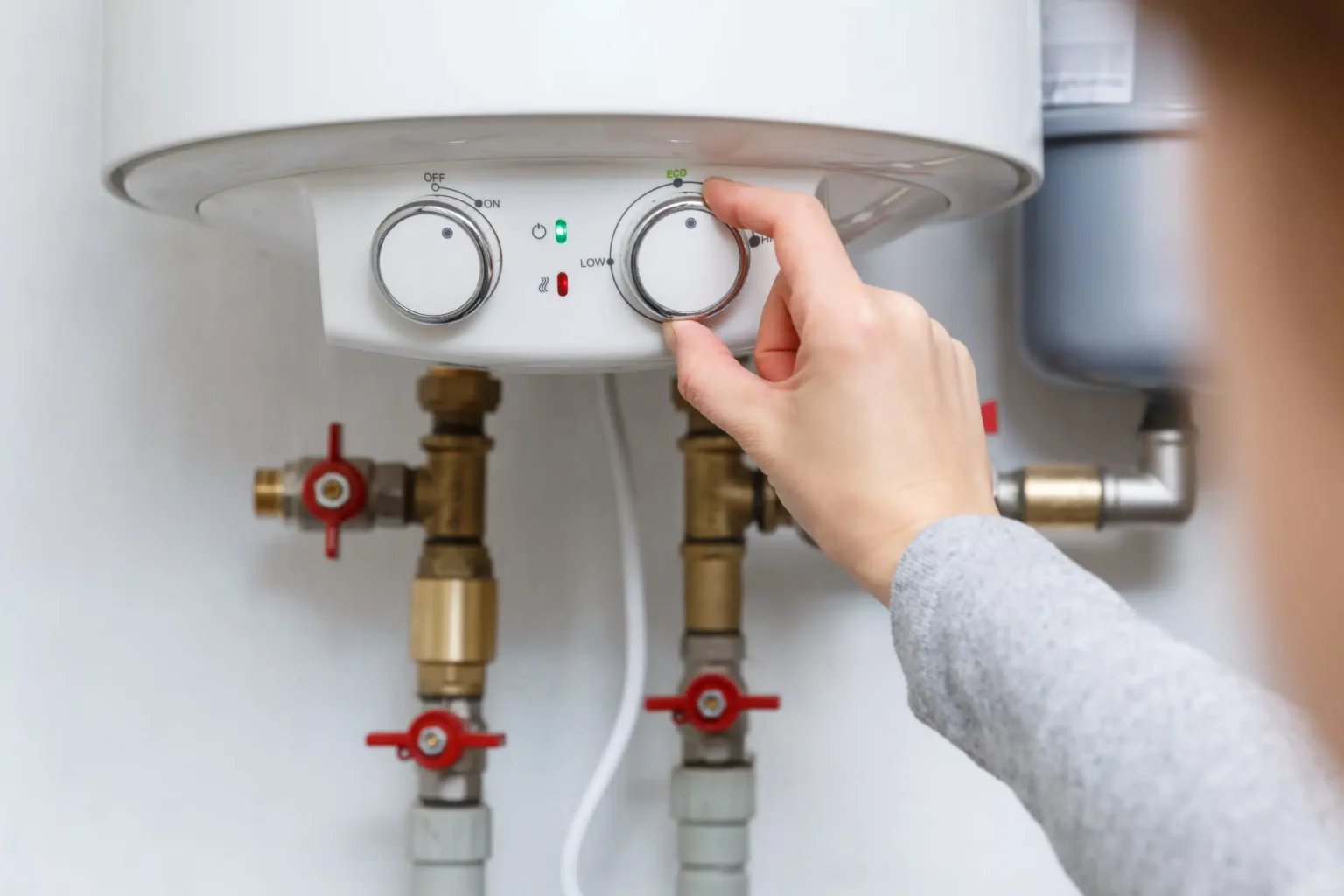 Homeowner adjusting the temperature controls on a water heater in Spring Hill