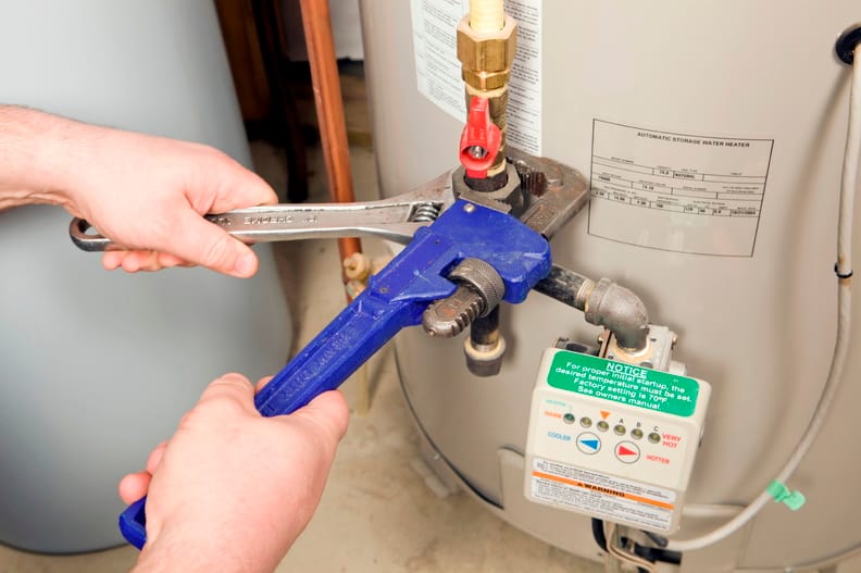 Plumber repairing a water heater valve in Spring Hill